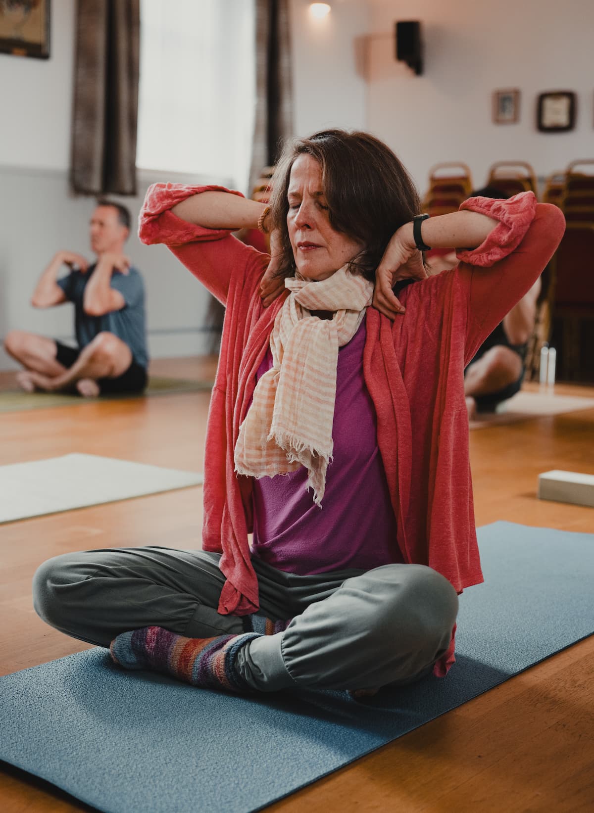 A student in a seated stretch during a class at Comrie Rural Hall.