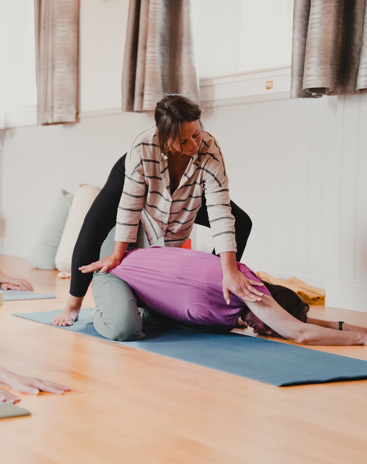 Caroline offering a hands-on assist to a student during class.