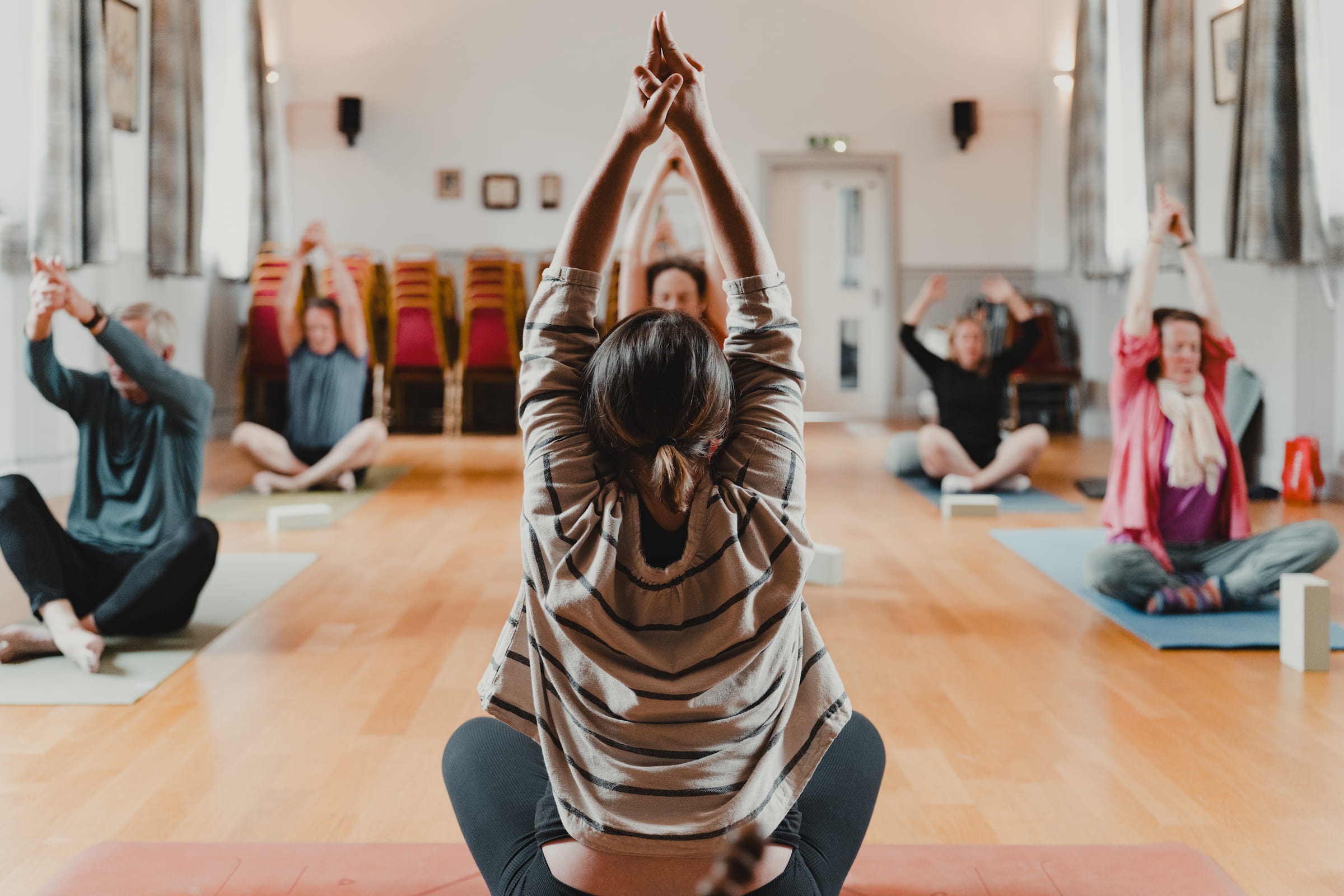 A candid yoga class in progress at Comrie Rural Hall, filled with soft natural light.