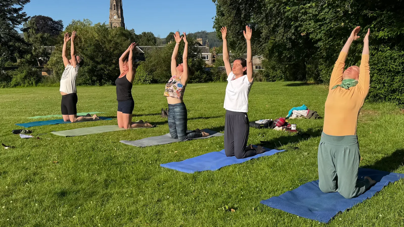 A group practising outdoors on the grass in the sunshine, beyond Comrie.